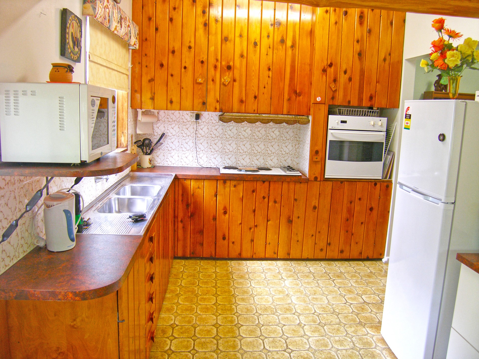 Wood panelled kitchen with fridge, oven & M/W
